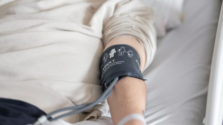 a man laying in a bed with a cast on his arm