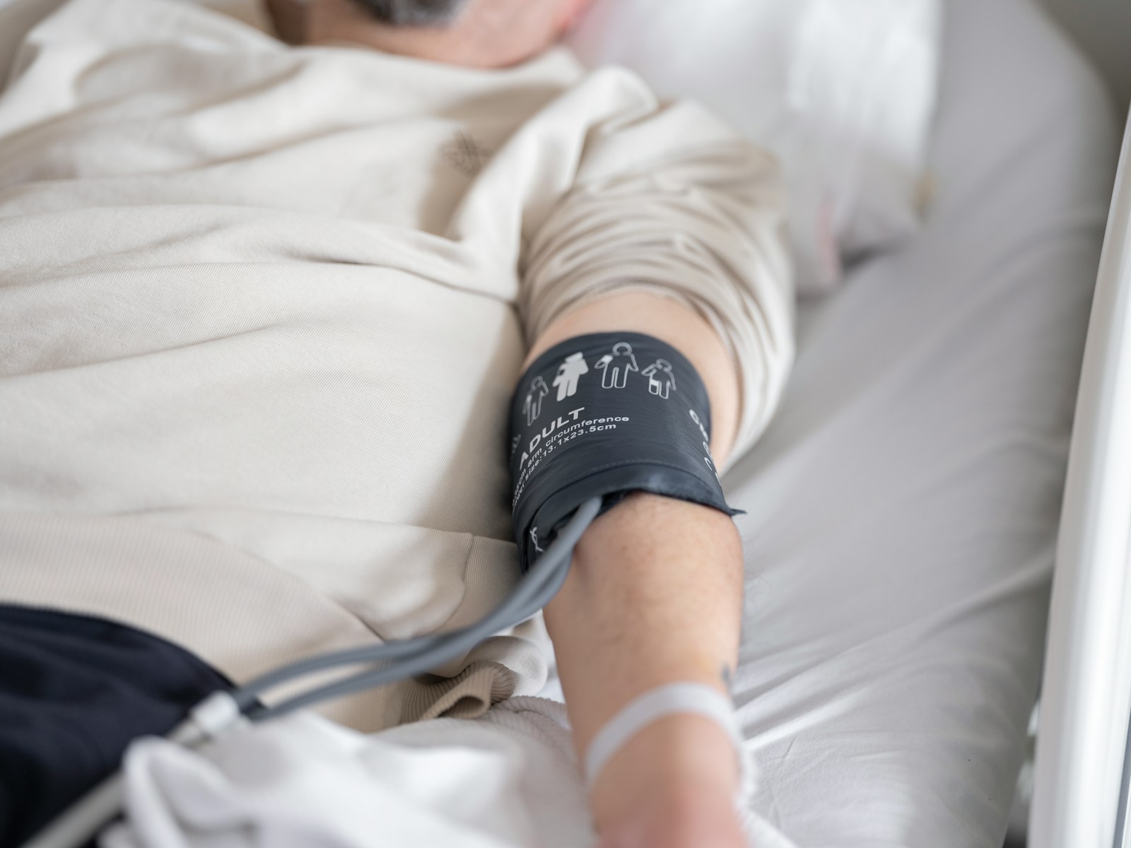 a man laying in a bed with a cast on his arm