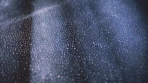 Close-up of shimmering bokeh lights on a textured dark surface creating an abstract pattern.