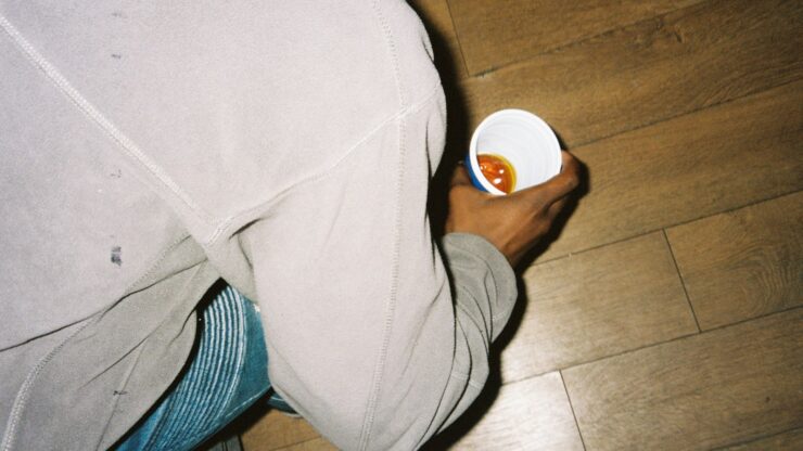 person in gray pants holding white plastic cup