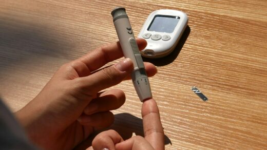 a person holding a pen and a cell phone on a table