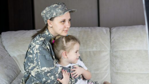 a woman in a military uniform holding a baby