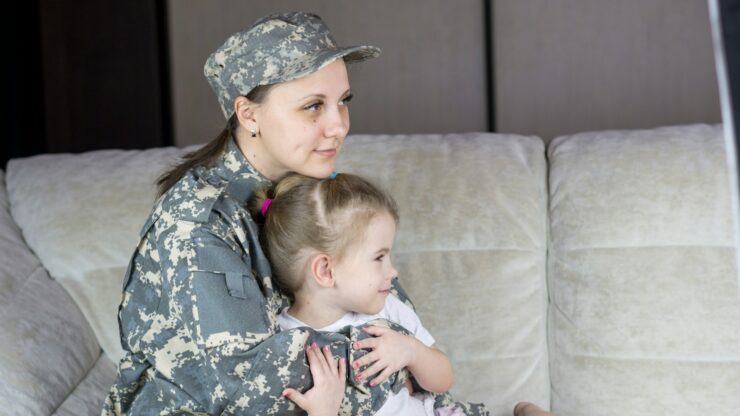 a woman in a military uniform holding a baby