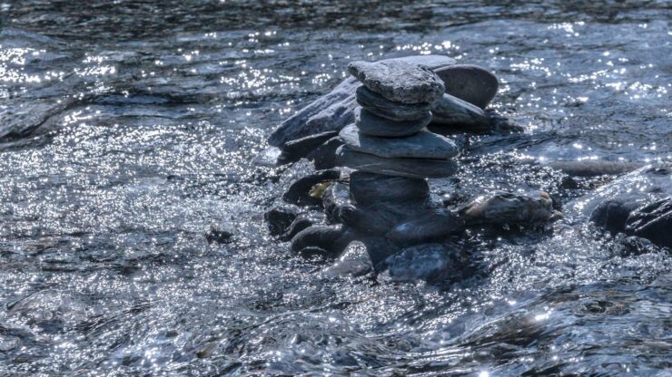 black stones on body of water during daytime