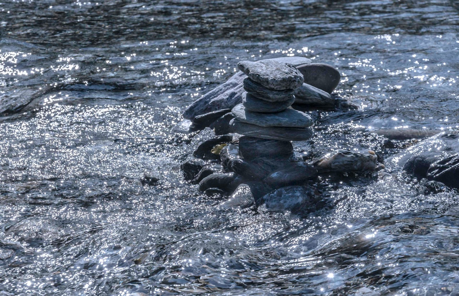 black stones on body of water during daytime