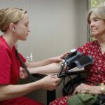 a woman with a stethoscope listening to a patient