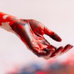 a person's hand with red and white paint on it