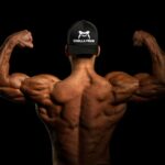 topless man wearing black and white cap