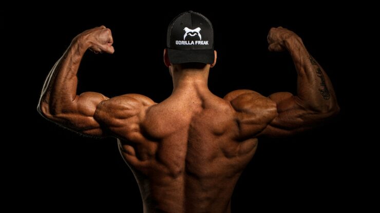 topless man wearing black and white cap