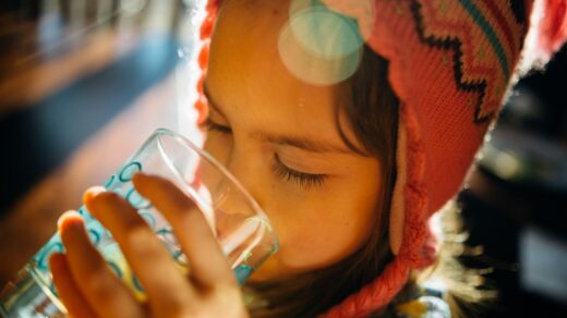 selective focus photography of girl drinking water