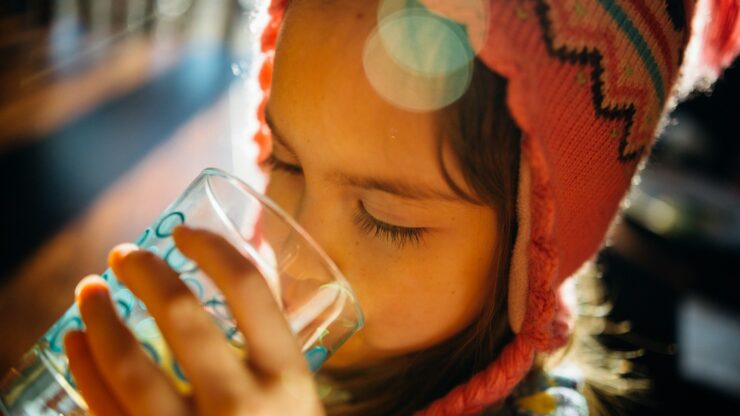 selective focus photography of girl drinking water