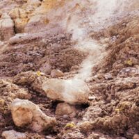 a rocky area with a white substance coming out of the ground