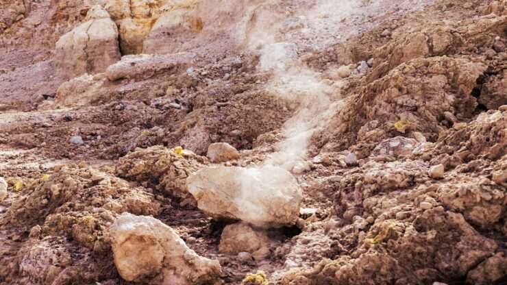 a rocky area with a white substance coming out of the ground