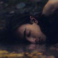 white short coated dog lying on water