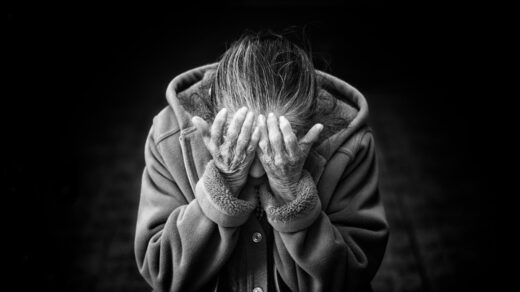 grayscale photography of person covering face