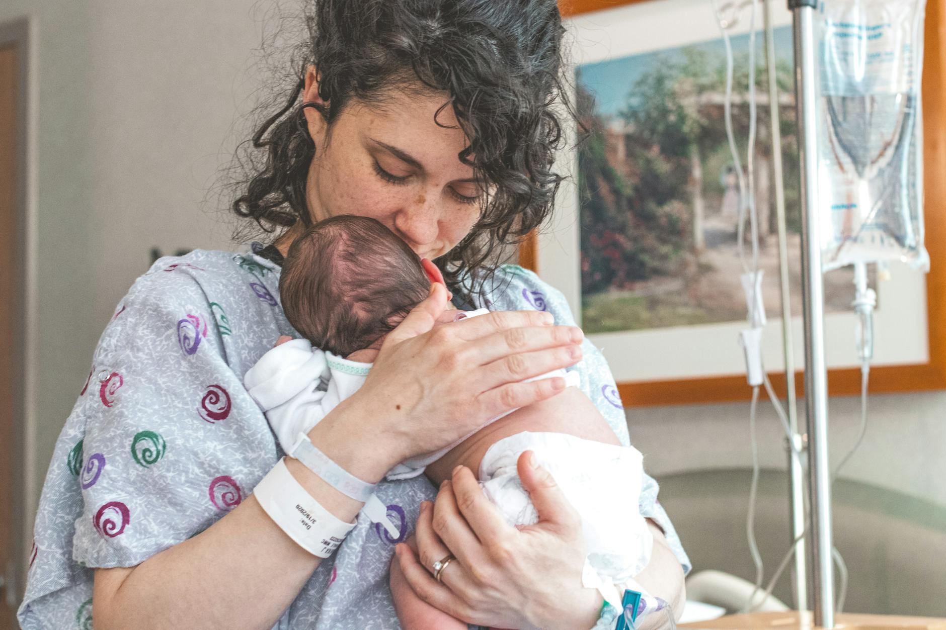 Mother gently holding newborn infant in a hospital maternity ward