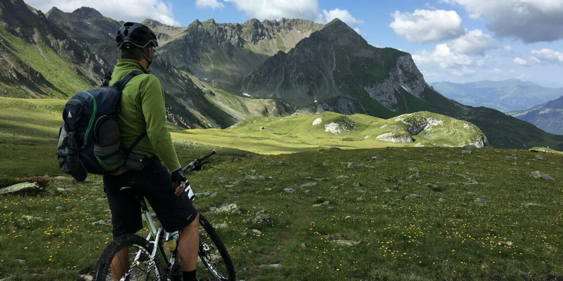 man riding bicycle on top of mountain