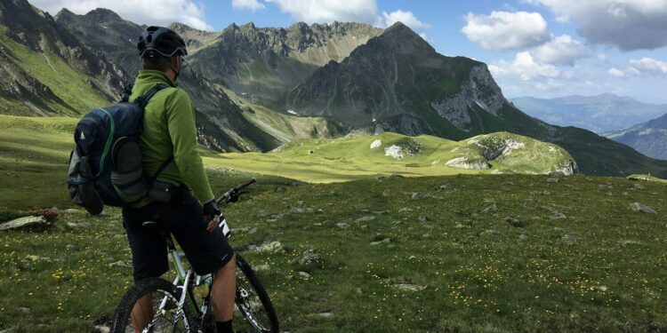 man riding bicycle on top of mountain